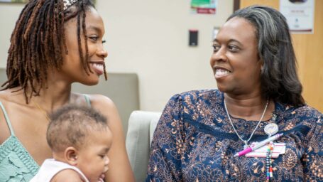 Mom holding baby in waiting room with CHW